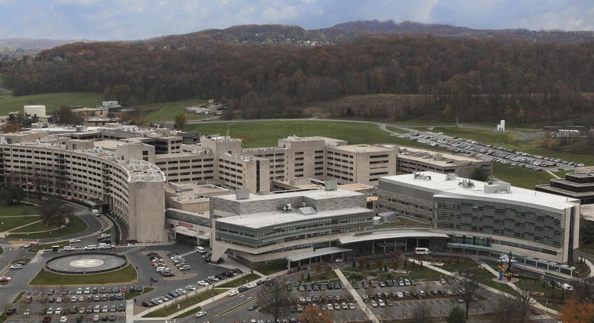 Aerial photo of a complex of buildings (Penn State Health Milton S. Hershey Medical Center) with mountains in the background.