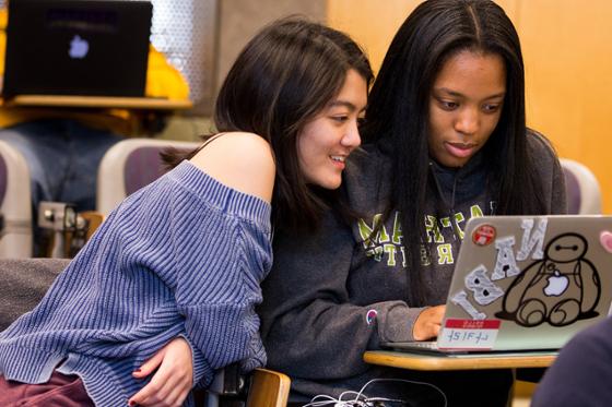 Photo of two female Chatham University students looking at a computer together
